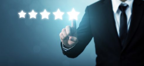Businessman pointing five star symbol to increase rating of company